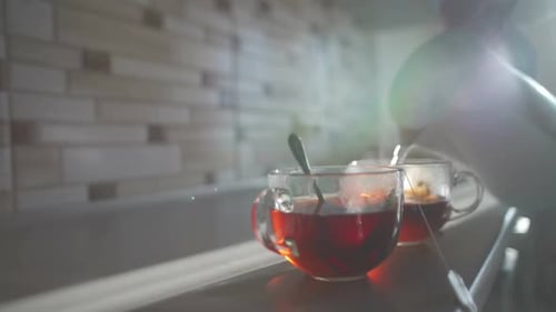 Woman pours hot water from a teapot