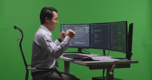 Developer Celebrating And Dancing While Write Code With Multiple Computer Screens In Green Screen