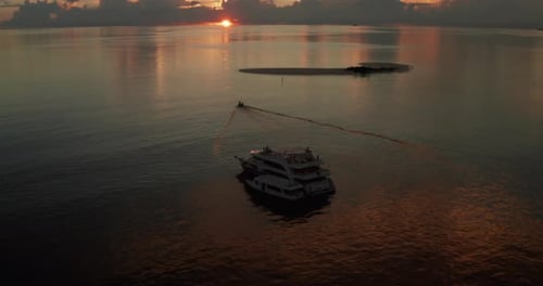 Luftaufnahme einer Yacht bei Sonnenuntergang inmitten des unberührten Meeres.