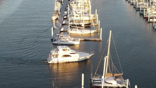 Luxury Motor Yacht Arriving At Marina With Moored Boats. - aerial