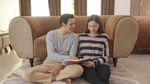 Couple Looking at Photo Album Together in Home