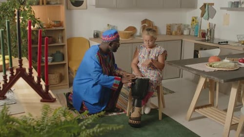Grandfather teaching his granddaughter how to play drum