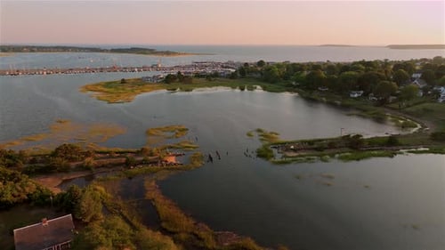 Aerial view of a coastal town with a serene harbor at sunset. Cape Cod, USA