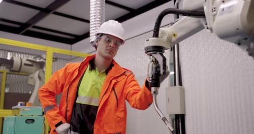 Ingenieur überprüft die Bewegung des Roboterschweißarms während einer Schulung zur Automatisierung in Zeitlupe in der Industrie40