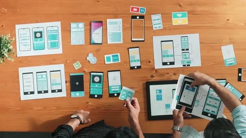 App Developers Design UI Mockups on Wooden Table