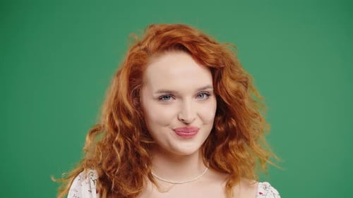 Red-Haired Woman Smiles and Winks on Green Screen