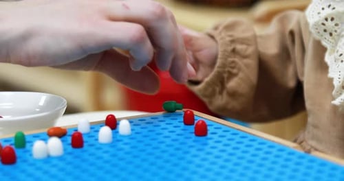 Child Playing Sorting Game with Colorful Pieces