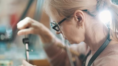 Focused Jeweler Crafting Handmade Jewelry in Workshop