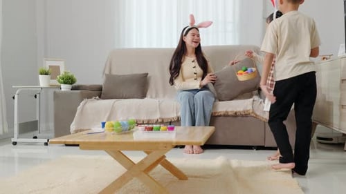 A Mother and Her Two Little Children are Wearing Bunny Ears While Searching for Colorful Easter Eggs