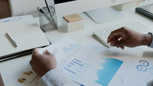 Reviewing Business Data Charts at Desk