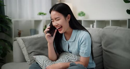 Smiling Woman Talking on Smartphone in Living Room