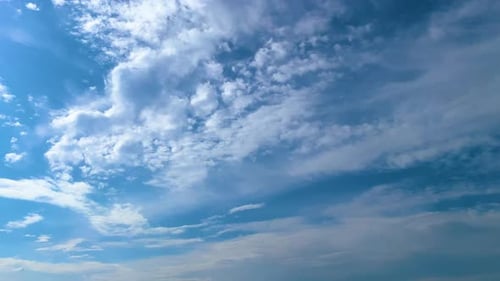 Cumulus Clouds Drifting in Bright Blue Daytime Sky
