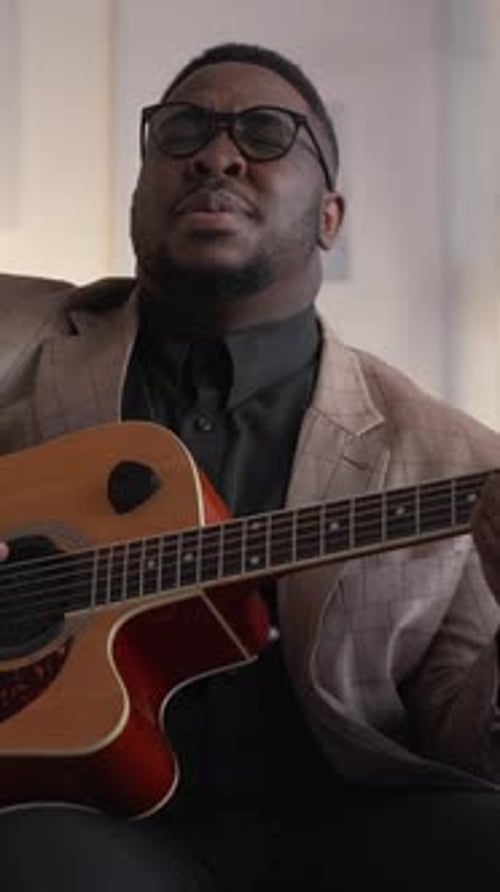 Man Playing Guitar and Singing Indoors