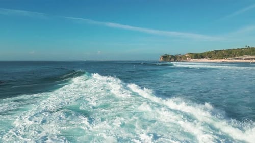 Luftaufnahme von Balangan Beach Bali mit türkisfarbenen Wellen, der Küste und klarem Himmel