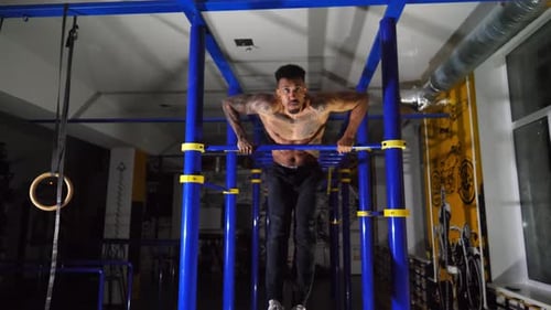 Strong African Sportsman Doing Exercises on Horizontal Bar at Modern Gym Muscular Afro American Man