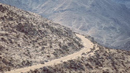 Scenic Winding Road Through Rocky Mountainous Terrain in Daylight Hours