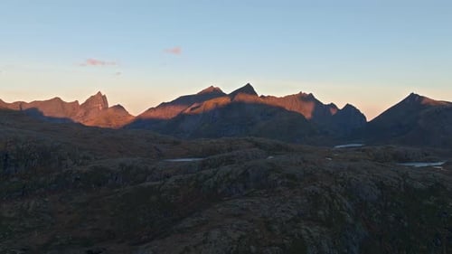 The sun setting across the mountaintops in Lofoten Norway