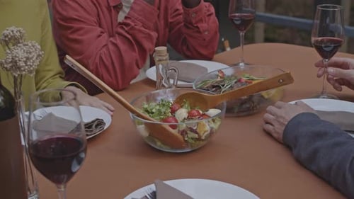 Close-Up of Friends Having Conversation at Dinner Table Outdoors