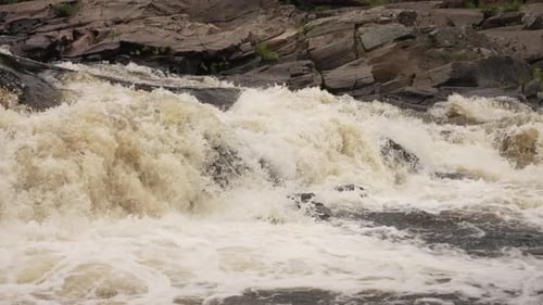Slow motion white water rapids rushing down a river in a violent force.