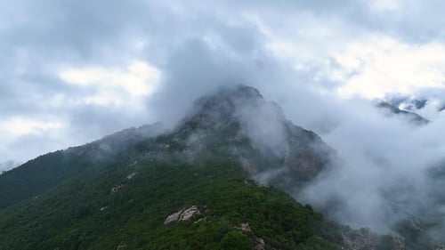 Mountain landscape shrouded in clouds at dawn in a serene environment