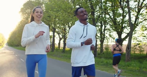 Portrait of Mixedrace Couple Man and Woman Athletes Running on Street Outside Together Couple