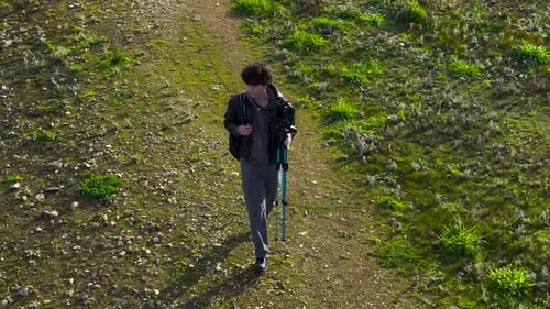 Man Walking On Field With Tripod And Digital Camera - Drone Shot