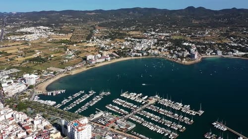 Aerial drone footage of a beach in the village of Sant Antoni on the island of Ibiza in Spain