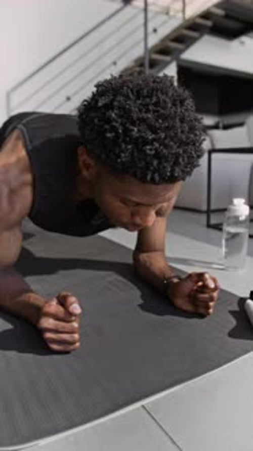 Man Does Plank Exercise on Mat Inside Home
