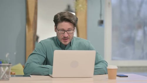 Man on Video Call Using Laptop in Office