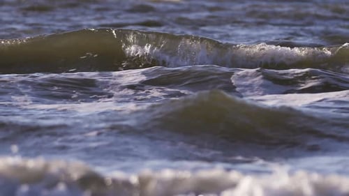 Sea waves rushing at the beach. Slow Motion Ocean White water Wave surf crashing. Medium shot.