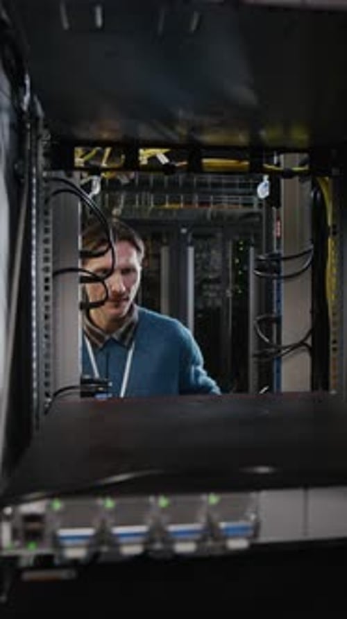 Technician Inspecting Server Rack in Data Center