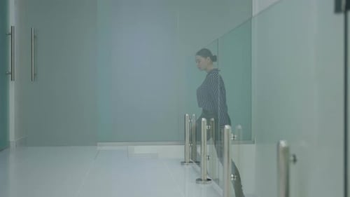 Woman Climbs Stairs in Glass Office Center Concept of Professional Service