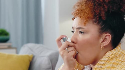 Woman Using Inhaler for Asthma Treatment Indoors