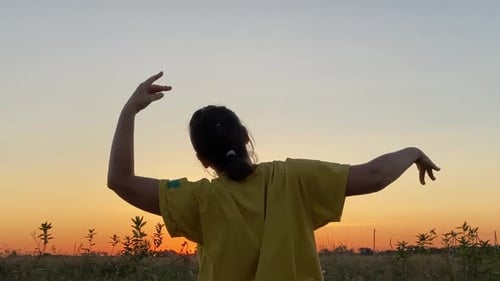 Woman Dancing at Sunset in Rural Field