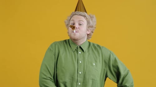 Man in Party Hat Blows Party Horn