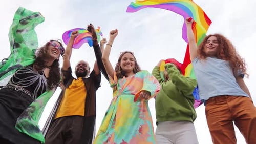 Diverse Young Adults Cheering with Pride Flags