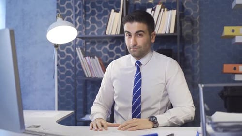 Man in White Shirt at Desk in Office