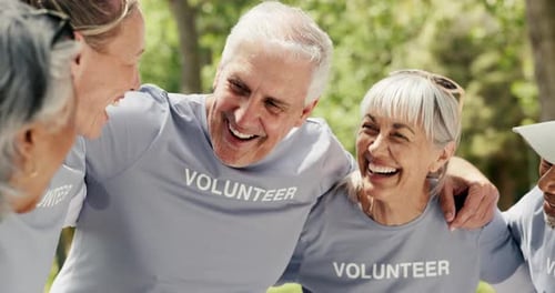Smiling Volunteers Huddled Together Outside in a Park