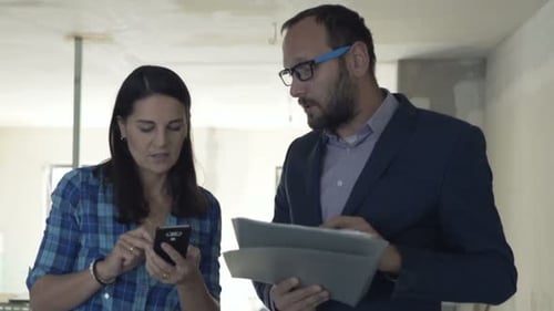 Businessman, Real Estate Agent with Client Checking Documents with Smartphone at New
