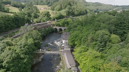 River Dee rapids, historic A5 road and Railway and Chain bridge seen from a drone