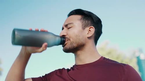 Fitness, tired and outdoor man drinking water for sports thirst hydration