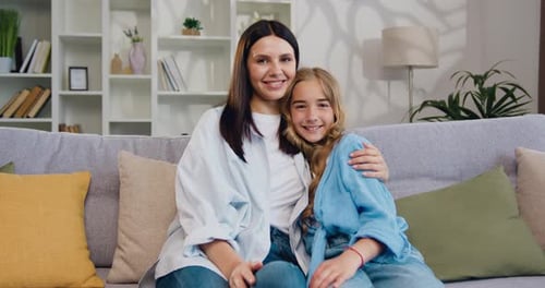 Mother and Daughter Sitting Together on Sofa