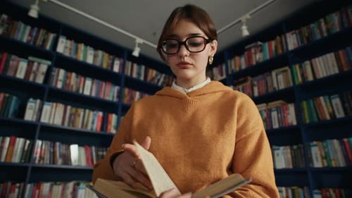 Konzentrierte Studentinnen lesen Buch in der modernen Bibliothek