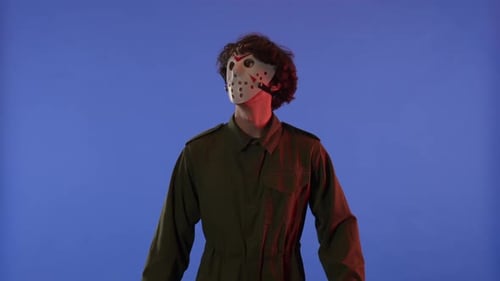 Man in White Mask Looking Around and Showing LIKE Gesture with Fingers on Blue Background with Red