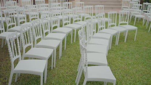 White Chairs Set Up for an Outdoor Wedding