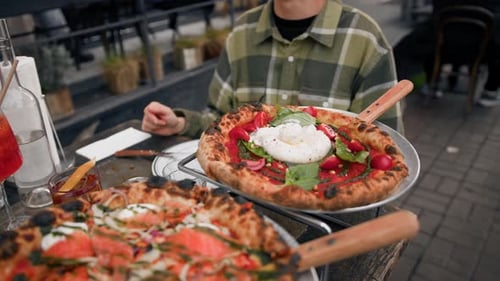 Close-up - the process of eating pizza on the terrace of a restaurant on the street