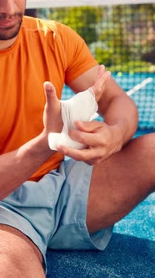 Athlete, man and bandage hand on tennis court from sports injury, fitness mistake and first aid