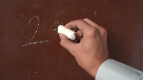 Hand Writes Math Problem on Chalkboard