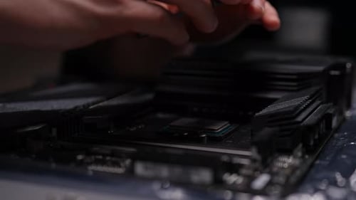 Closeup of Technician Hands Carefully Installing CPU Into Motherboard Socket of Computer