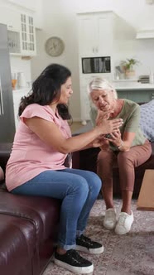 Women Looking at Mobile Phone in Home